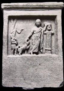 Grabstele d. Diodoros, Er streckt seinen re. Arm in Richtung des Spitzes aus, der seine re. Vorderpfote hebt., Samos, 2. Jh. v. Chr., © Vathy Museum, Samos