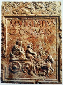 Grabstele für Marcus Viriatius Zosimus, der mit einer Kutsche in Begleitung eines Hundes ins Jenseits geführt wird. 1. Jh. n. Chr. ©  Museo Archeologico del Teatro Romano (Verona), Inventarnummer 28154