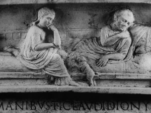 Kleiner Schoßhund beim Versuch, auf eine Kline (Bett/Sofa) zu springen. Grabstein des Tiberius Claudius Dionysius, Fundort Rom, (früh-) claudische Zeit, Aus: Katalog der Skulpturen. Vatikanische Museen. Museo Gregoriano Profano ex Lateranense. Bd. 1, 1. Mainz 1991. Nr. 10. S. 32f. Abb. S. 152., © Museo Vaticano
