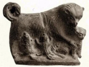 Terrakotta mit der Darstellung einer sich um ihren Wurf kümmernden Hündin mit ihren drei Welpen. Aus: Perdrizet, Paul, Les Terres cuites grecques d´Égypte de la collection Fouquet. Vol. 1. Text. Nancy 1921. Nr. 398. S. 146. Fundort und genaue Datierung unklar, Sammlung Fouquet