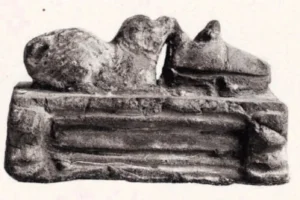 Terrakotta 01 ,,Welpe mit Schuh‘‘, Achmounéin (ca. 300 Km südl. v. Kairo), aus: Perdrizet. Vol. 1. Nr. 399. S. 146, keine genaue Datierung